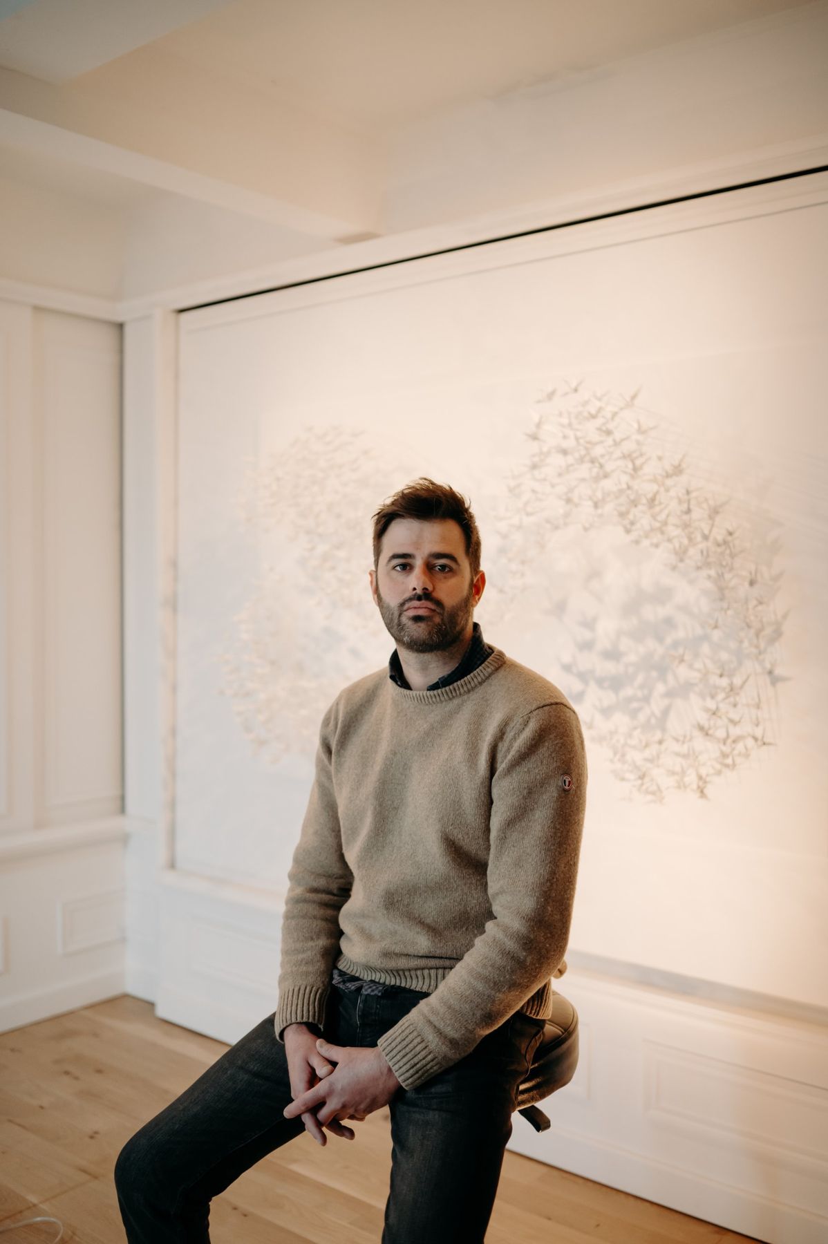 Benjamin Gaumard, seated in three-quarter view in front of a paper Murmuration.