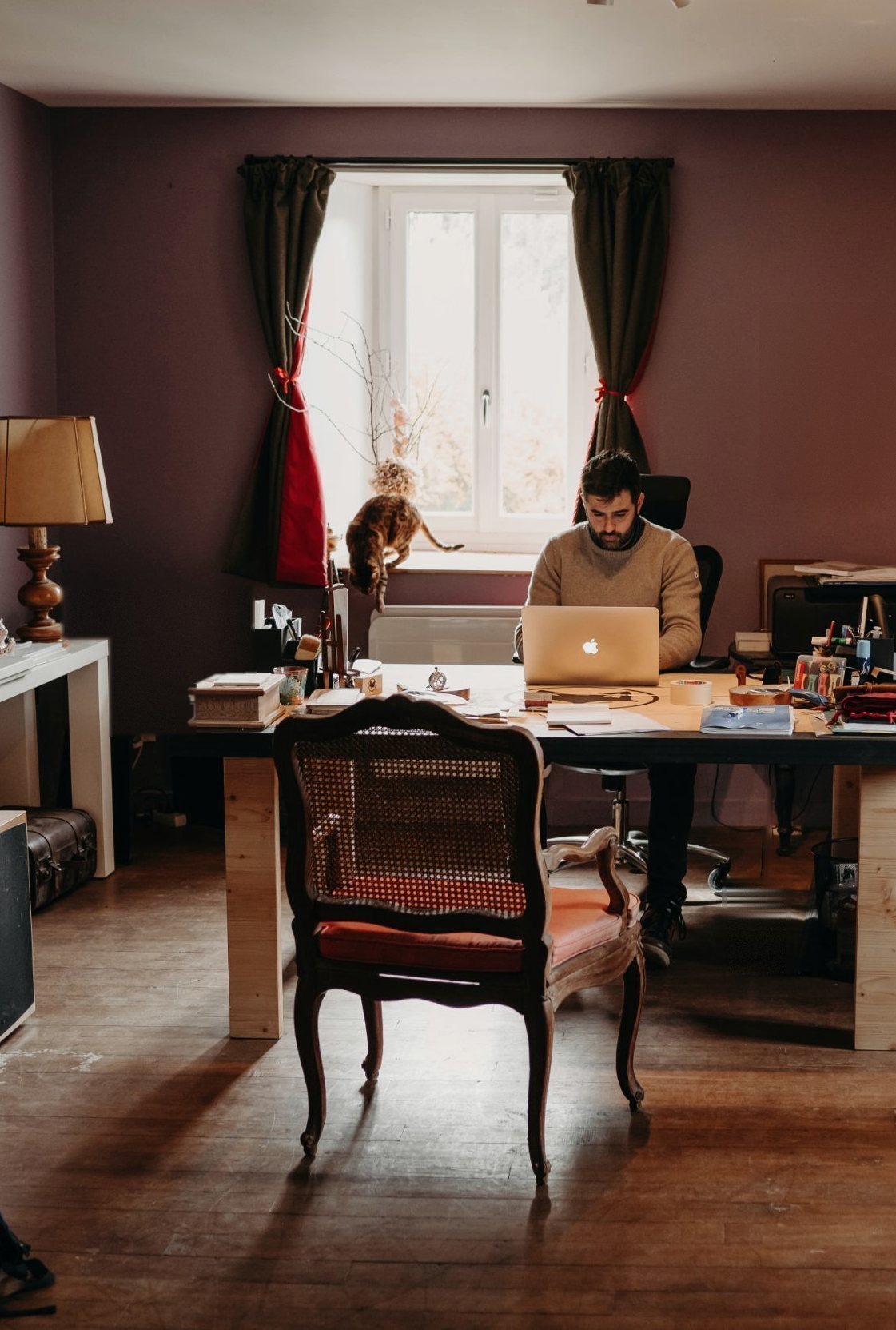Benjamin Gaumard working at his desk in the studio, by a window.